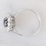 Anello a margherita vintage in oro bianco 18K con zaffiro (1ct ca.) e diamanti di taglio brillante (0.70ctw ca.), anni ‘70