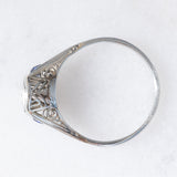 Solitario Art Déco in oro bianco 18K con diamante di taglio brillante (0.08ct ca.) e zaffiri di taglio triangolare, anni ‘30