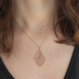 Pendente antico lavalier in oro giallo 9K con pasta di vetro azzurra e perline bianche, anni ‘10/‘20