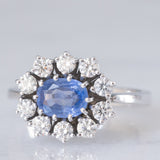 Anello a margherita in oro bianco 18K con zaffiro azzurro (0.80ct ca.) e diamanti di taglio brillante (0.70ctw ca.), anni ‘70/‘80