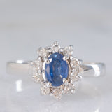 Anello a margherita vintage in oro bianco 18K con zaffiro (0.50ct ca.) e diamanti di taglio brillante (0.25ctw ca.), anni ‘80