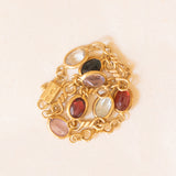Bracciale vintage in oro giallo 18K con granati, ametiste, acquamarina, spinello blu sintetico e zaffiro bianco, anni ‘70