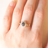 Anello a margherita vintage in oro giallo e bianco 9K con zaffiro (0.60ct ca.) e diamanti (0.14ctw ca.), anno 1991