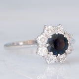 Anello a margherita vintage in oro bianco 18K con zaffiro (1.20ct ca.) e diamanti di taglio brillante (0.80ctw ca.), anni ‘70