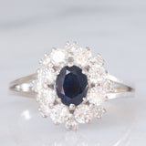 Anello a margherita vintage in oro bianco 18K con zaffiro (1.30ct ca.) e diamanti di taglio brillante (1.30ctw ca.), anni ‘70