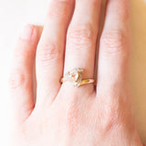 Anello in oro giallo e bianco 9K con zaffiro rosa chiaro sintetico di taglio trillion (0.65ct ca.) e zaffiri bianchi, anni ‘80