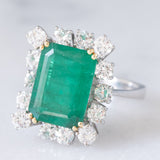Anello a margherita vintage in oro bianco 14K con smeraldo (5.50ct ca.) e diamanti di taglio brillante (1.65ctw ca.), anni ‘70