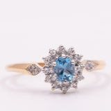 Anello a margherita vintage in oro giallo 9K con topazio azzurro (0.45ct ca.) e diamanti (0.14ctw ca.), anni ‘90