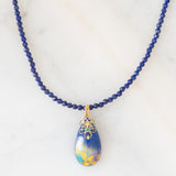 Collana moderna con filo di vetri blu e con pendente in oro giallo 18K con lapislazzuli, smeraldo e diamante