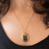 Ciondolo portafoto antico in oro giallo 18K con smalti neri e perlina bianca, primi del ‘900