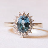 Anello a margherita moderno in oro giallo e in oro bianco 9K con topazio azzurro (1.30ct ca.) e diamanti di taglio brillante (0.16ctw ca.), anni ‘70/‘80