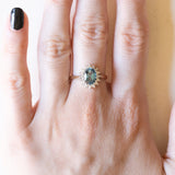 Anello a margherita moderno in oro giallo e in oro bianco 9K con topazio azzurro (1.30ct ca.) e diamanti di taglio brillante (0.16ctw ca.), anni ‘70/‘80