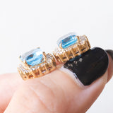 Orecchini a margherita vintage in oro giallo 14K con topazi azzurri (4.80ctw ca.) e diamanti di taglio brillante (0.72ctw ca.), anni ‘70/‘80