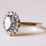 Anello a margherita moderno in oro giallo e in oro bianco 9K con topazio azzurro (1.30ct ca.) e diamanti di taglio brillante (0.16ctw ca.), anni ‘70/‘80