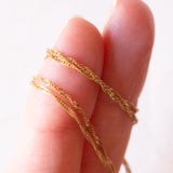 Collana con catenina in oro giallo 9K e con ciondolo in oro giallo 9K con opale e rubini sintetici, anni ‘80/‘90