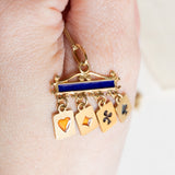 Ciondolo vintage in oro giallo 18K con smalti blu e con quattro carte pendenti con smalti arancioni e neri, anni ‘60