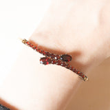 Braccialetto vintage con serpenti stilizzati in oro giallo 8K con granati (4ctw ca.), anni ‘60