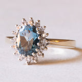 Anello a margherita moderno in oro giallo e in oro bianco 9K con topazio azzurro (1.30ct ca.) e diamanti di taglio brillante (0.16ctw ca.), anni ‘70/‘80