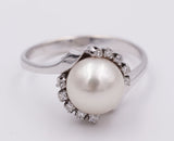 Anello vintage in oro con perla centrale e diamanti laterali .