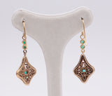 Liberty earrings in gold and silver with emeralds and diamond rosettes.