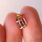 Lotto comprendente ciondolo in oro 18K con ametista, ciondolo in oro 18K a forma di “Uomo della Luna” in oro 18K e ciondolo in oro 9K a forma di elefantino