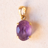 Lotto comprendente ciondolo in oro 18K con ametista, ciondolo in oro 18K a forma di “Uomo della Luna” in oro 18K e ciondolo in oro 9K a forma di elefantino