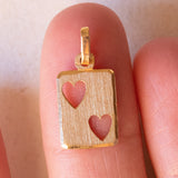 Lotto comprendente ciondolo in oro 18K con zircone e ciondolo a forma di carta di due di cuori in oro 18K