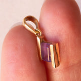 Lotto comprendente ciondolo in oro 18K con ametista, ciondolo in oro 18K con zaffiro e ciondolo a forma di chiave di violino in oro 18K