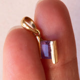 Lotto comprendente ciondolo in oro 18K con ametista, ciondolo in oro 18K con zaffiro e ciondolo a forma di chiave di violino in oro 18K