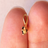 Lotto comprendente ciondolo in oro 18K con ametista, ciondolo in oro 18K con zaffiro e ciondolo a forma di chiave di violino in oro 18K