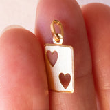 Lotto comprendente ciondolo in oro 18K con zircone e ciondolo a forma di carta di due di cuori in oro 18K