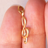 Lotto comprendente ciondolo in oro 18K con ametista, ciondolo in oro 18K con zaffiro e ciondolo a forma di chiave di violino in oro 18K