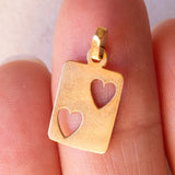 Lotto comprendente ciondolo in oro 18K con zircone e ciondolo a forma di carta di due di cuori in oro 18K