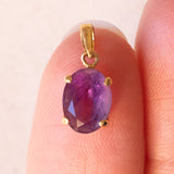 Lotto comprendente ciondolo in oro 18K con ametista, ciondolo in oro 18K a forma di “Uomo della Luna” in oro 18K e ciondolo in oro 9K a forma di elefantino