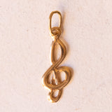 Lotto comprendente ciondolo in oro 18K con ametista, ciondolo in oro 18K con zaffiro e ciondolo a forma di chiave di violino in oro 18K