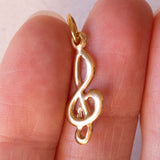 Lotto comprendente ciondolo in oro 18K con ametista, ciondolo in oro 18K con zaffiro e ciondolo a forma di chiave di violino in oro 18K