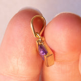 Lotto comprendente ciondolo in oro 18K con ametista, ciondolo in oro 18K con zaffiro e ciondolo a forma di chiave di violino in oro 18K