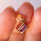 Lotto comprendente ciondolo in oro 18K con ametista, ciondolo in oro 18K con zaffiro e ciondolo a forma di chiave di violino in oro 18K