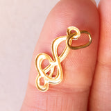 Lotto comprendente ciondolo in oro 18K con ametista, ciondolo in oro 18K con zaffiro e ciondolo a forma di chiave di violino in oro 18K