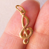 Lotto comprendente ciondolo in oro 18K con ametista, ciondolo in oro 18K con zaffiro e ciondolo a forma di chiave di violino in oro 18K