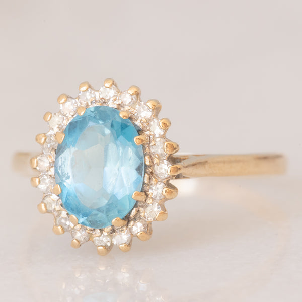 Anello a margherita vintage in oro giallo 9K con topazio azzurro (1.50ct ca.) e diamanti (0.10ctw ca.), anno 1988