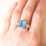 Anel de coquetel vintage em ouro branco 18K com topázio azul (aprox. 8.50 ct) e diamantes lapidação baguete (aprox. 0.80 ctw), década de 80