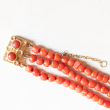 Vintage dreisträngiges Armband aus orangefarbenen Korallenperlen mit Verschluss aus 14 Karat Gelbgold und orangefarbener Koralle, 60er Jahre