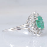 Anello a margherita vintage in oro bianco 14K con smeraldo (1ct ca.) e diamanti di taglio brillante (0.72ctw ca.), anni ‘70/‘80