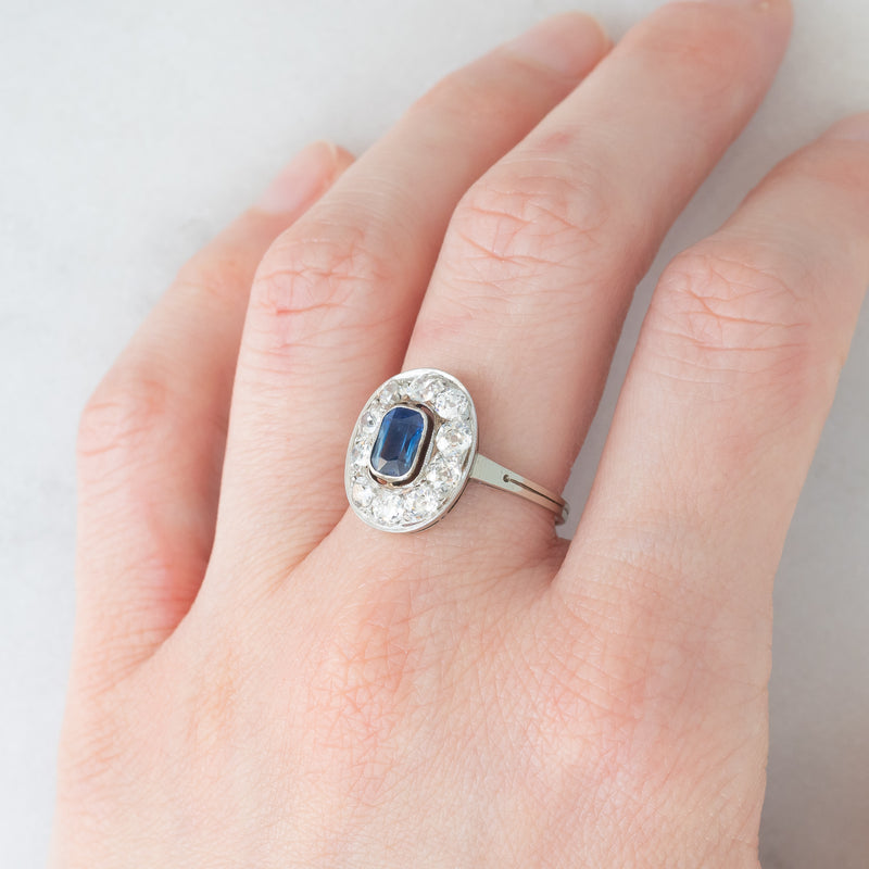 Anello a margherita antico in oro bianco con zaffiro (0.70ct ca.) e diamanti di taglio vecchia miniera (1ctw ca.), anni ‘20/‘30