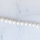 Braccialetto vintage con filo di perle bianche e chiusura in oro giallo 14K