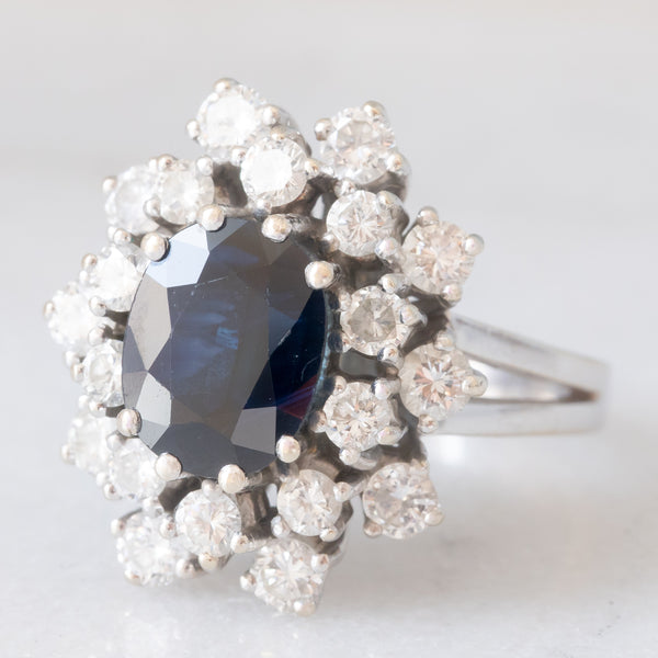 Anello a margherita vintage in oro bianco 14K con zaffiro (2.60ct ca.) e diamanti di taglio brillante (1.50ctw ca.), anni ‘60