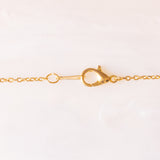 Collana con catenina in argento dorato e con tre ciondoli a forma di delfino in oro giallo 18K, di ancora in oro giallo 18K e di tartaruga in oro giallo 14K
