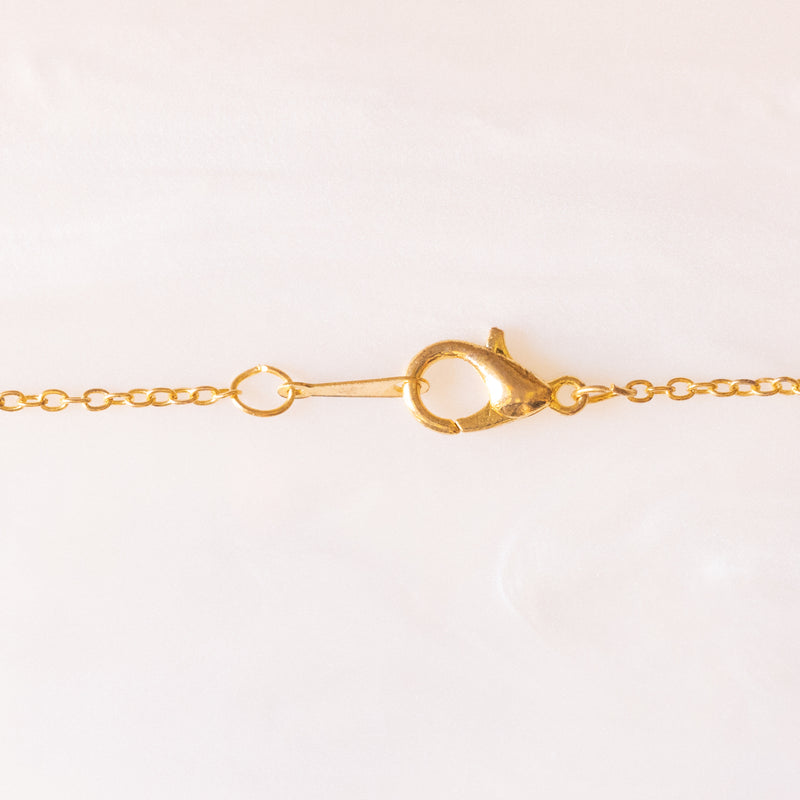 Collana con catenina in argento dorato e con tre ciondoli a forma di delfino in oro giallo 18K, di ancora in oro giallo 18K e di tartaruga in oro giallo 14K