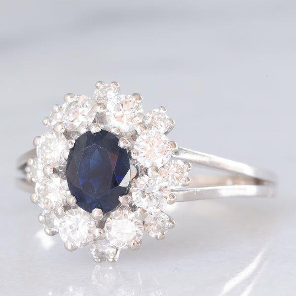 Anello a margherita vintage in oro bianco 18K con zaffiro (1.30ct ca.) e diamanti di taglio brillante (1.30ctw ca.), anni ‘70